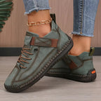 Sage green suede-look trainer with brown trim, elastic side strap and tan lug sole shown from side angle