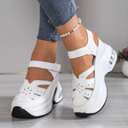 Side view of white chunky platform sandal with ankle strap, T-bar cutouts and floral perforated detailing