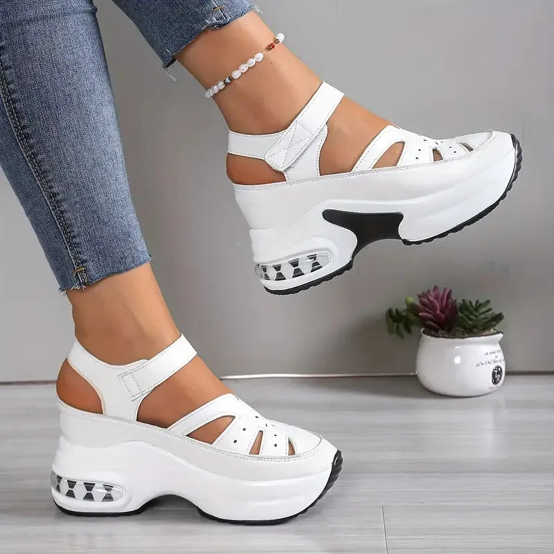 White platform sandals with crisscross cutout straps and visible cushioned midsole, styled with jeans