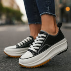 Black and white canvas platform trainer with contrast white toe cap and gum-tone ridged outsole, paired with denim