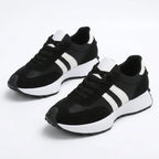 Pair of black retro trainers with white side stripes and white heel tab, shown together on a plain background