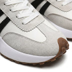 Close-up of the white trainer's textured toe cap, suede panels and black stripe stitching detail