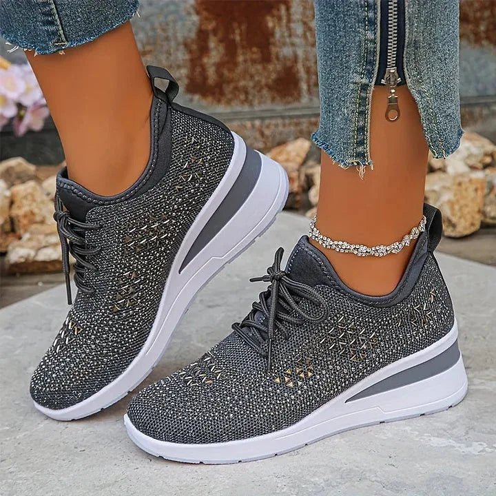 Pink knit trainers on foot with focus on ankle strap loop and cushioned wedge sole