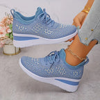 Pink knit trainers with clear rhinestone star pattern, worn on foot showing lace-up front and wedge heel
