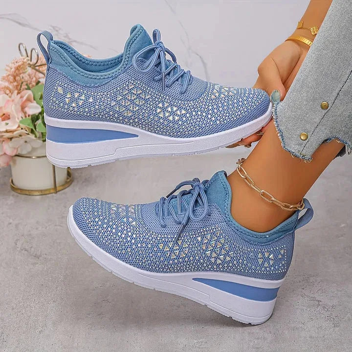 Pink knit trainers with clear rhinestone star pattern, worn on foot showing lace-up front and wedge heel