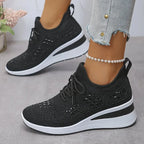Close-up side view of white knit trainers with silver sparkle detailing and textured white sole