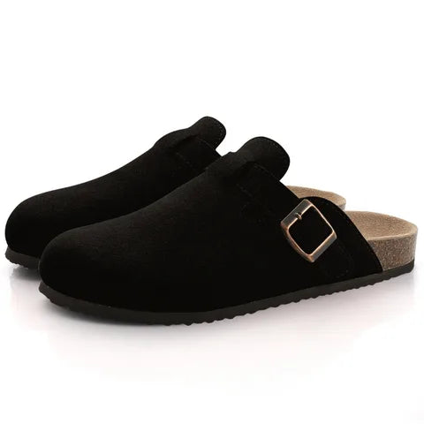 Pair of black suede clog slippers shown together, highlighting stitched toe seam and buckle fastening