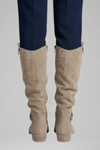 Close-up back view of both beige suede boots showing the ruched shaft and stacked block heel