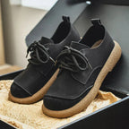 Close-up of the textured rubber sole and heel of a tan suede lace-up shoe