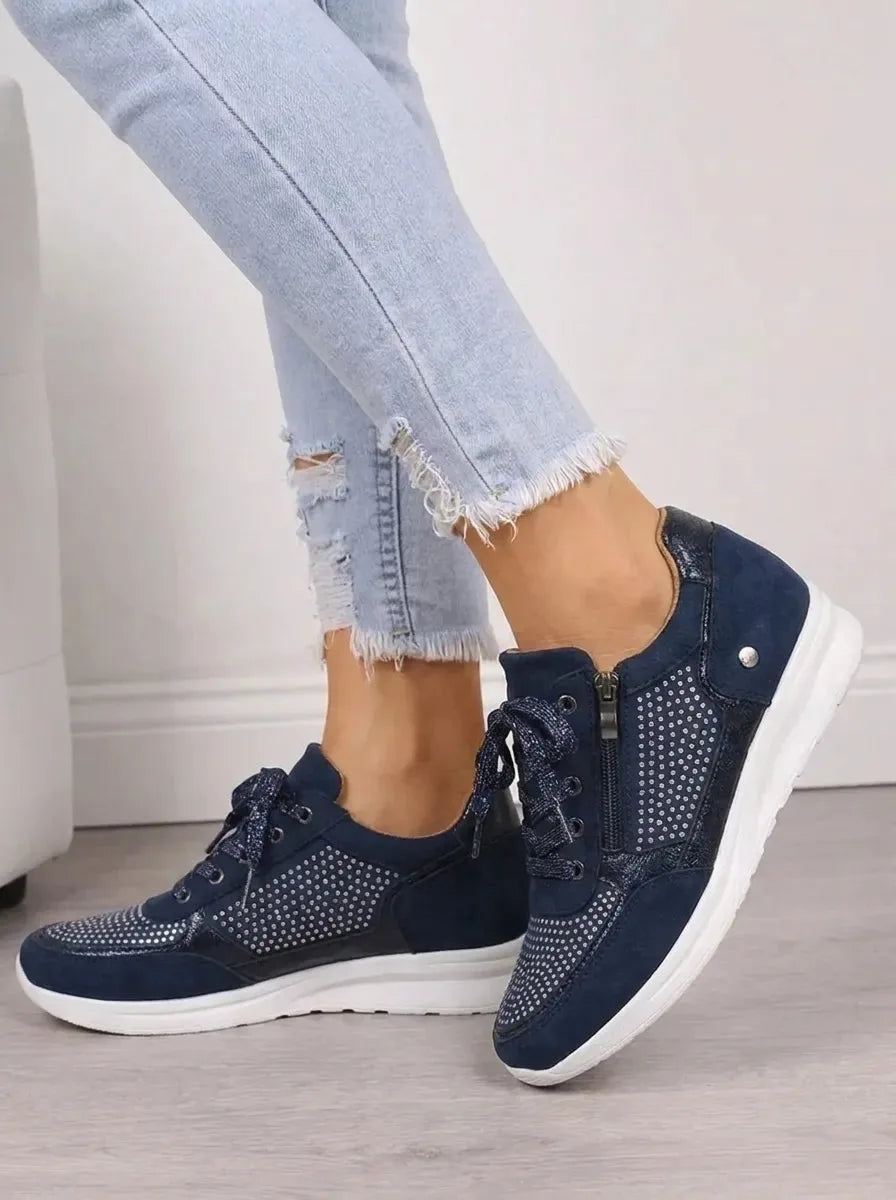 Side profile of navy trainers showing zip fastening, suede panels and white cushioned sole