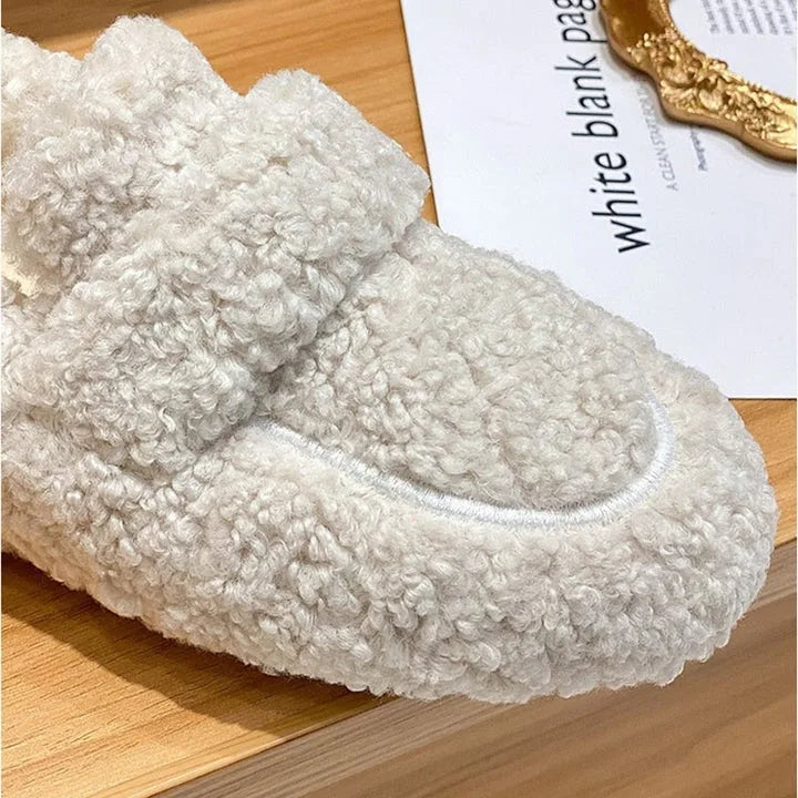 Close-up of the cream fleece upper showing the curled wool-like texture and stitched outsole edge