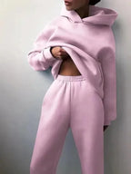 Woman posed casually showing the drop-shoulder sleeves and loose hoodie fit