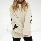 Front view of an oversized cream jumper with bold black lettering print across the sleeves