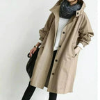 Camel coloured hooded trench coat with button placket and side pockets, worn over black leggings