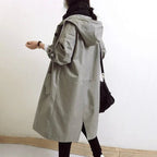 Back view of a grey hooded trench coat showing the elasticated cuffs and back seam detailing
