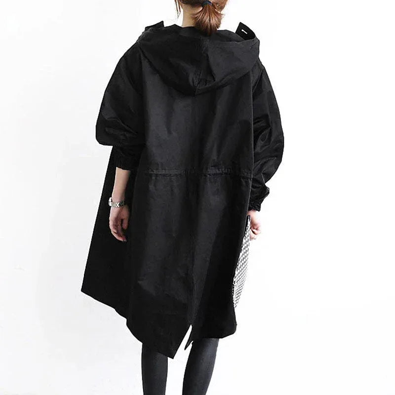 Back view of a black hooded trench coat highlighting the oversized hood and asymmetric hemline