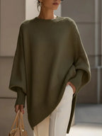 Close-up detail of the ribbed knit cuff and drop shoulder seam on the oversized beige jumper