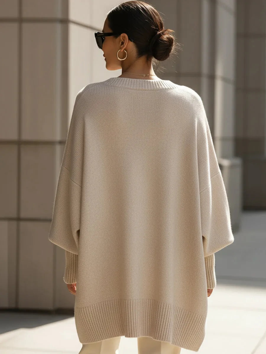 Back view of the beige batwing jumper showing the relaxed drape and ribbed cuff and hem finishing