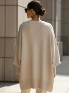 Back view of the beige batwing jumper showing the relaxed drape and ribbed cuff and hem finishing