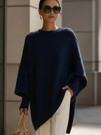 Model wearing the oversized poncho jumper in navy blue with a wide ribbed neckline and drop shoulders