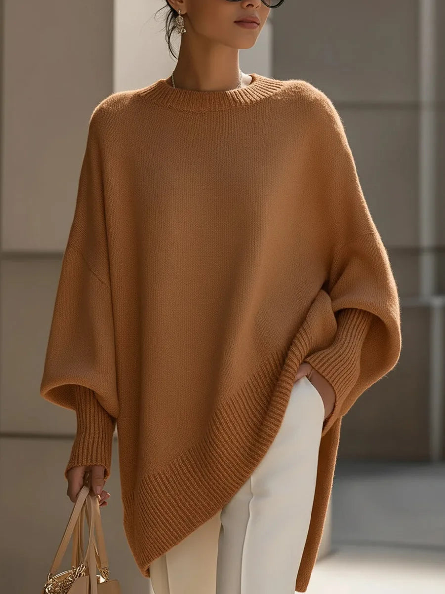 Model wearing the oversized poncho jumper in warm brown with hand resting in the side pocket opening