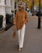 Camel-toned oversized jumper with ribbed cuffs and hem styled with white trousers and a tan handbag