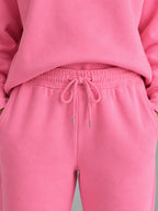 Close-up of the joggers' elasticated drawstring waistband with metal toggle ends in pink