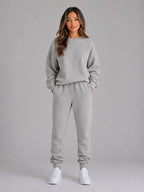 Full-length front view of the oversized tracksuit set in heather grey with white trainers