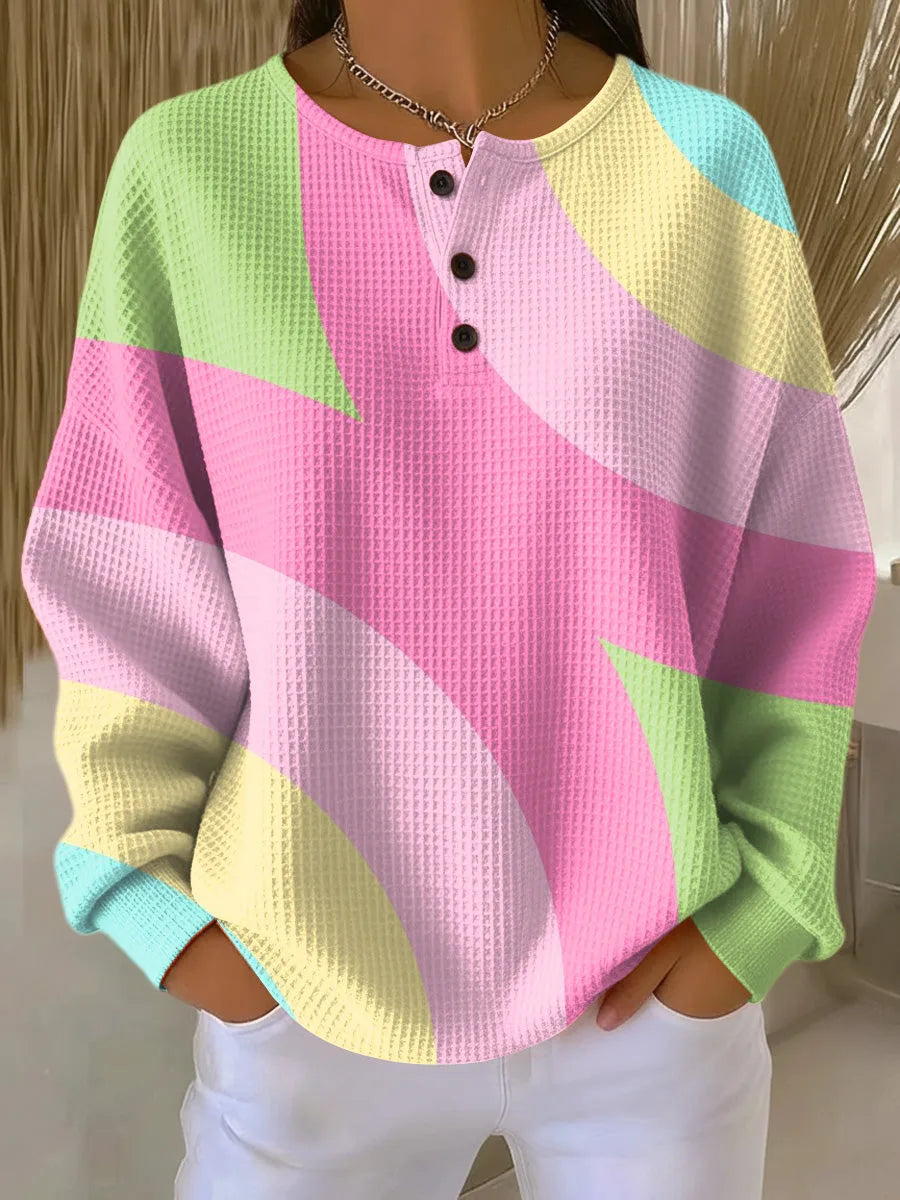 Close-up of a pastel pink, green, yellow and blue colour-block waffle-knit jumper with a three-button henley placket
