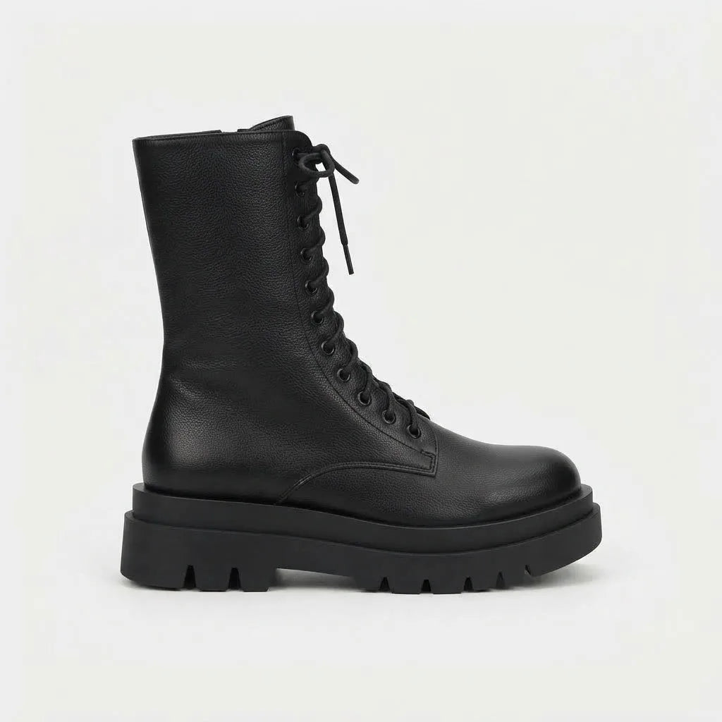 Side profile of black grained leather lace-up combat boot with chunky lugged platform sole