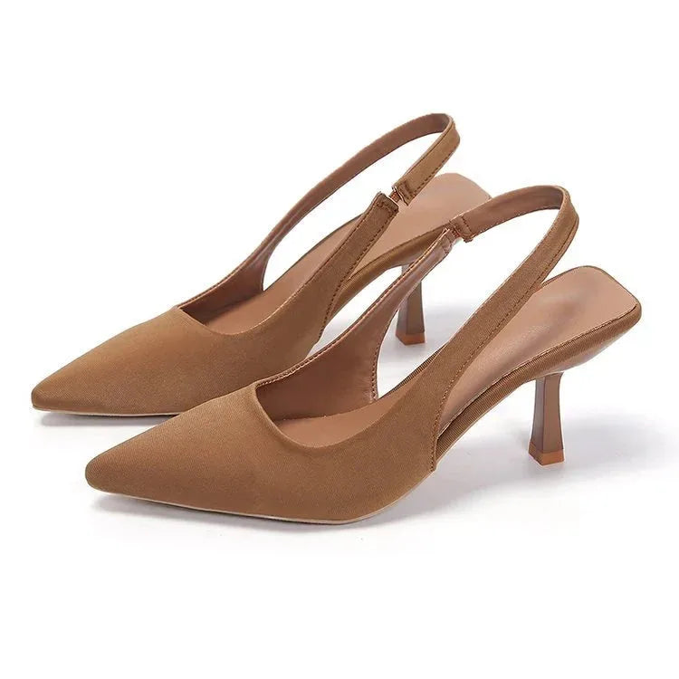 Side view of tan/khaki satin slingback pumps showing the adjustable elastic strap and curved heel