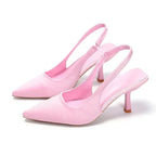 Soft pink satin slingback pumps with pointed toe, shown from the front on a white background