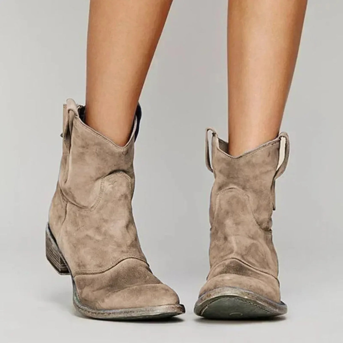 Taupe suede ankle boots showing the seamed front panel, pointed toe and contrast-toned stacked heel