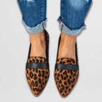Leopard-print pony hair loafers with black leather penny strap, front-facing view worn with cuffed denim