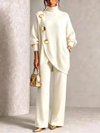 Cream polo neck knit set showing the ribbed cuffs and loose batwing sleeve detail