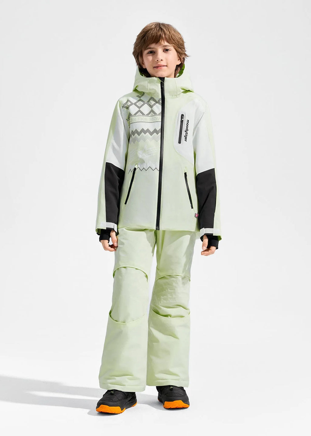 Front view of boy in pale green ski jacket and matching trousers, showing zip pockets and chest logo detail