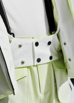 Close-up of the jacket's snap-button waist tab and interior powder skirt fastening in white and pale green