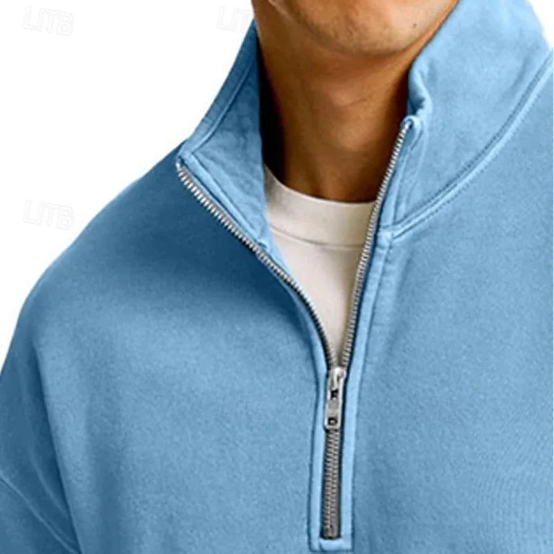 Close view of a light blue quarter-zip sweatshirt showing the ribbed hem and relaxed body fit