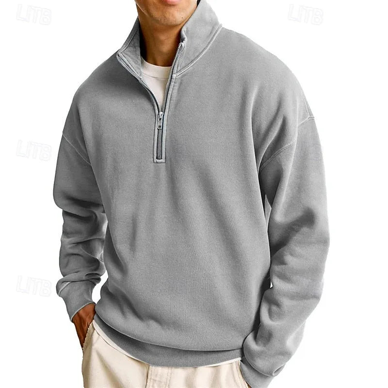 Close angled shot of a grey quarter-zip sweatshirt highlighting the stand collar and half-zip fastening