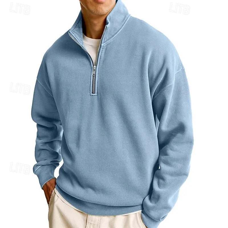 Man modelling a light blue quarter-zip sweatshirt with relaxed drop-shoulder fit and ribbed trim