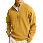 Close-up of the zip pull and stand collar on a navy blue quarter-zip sweatshirt