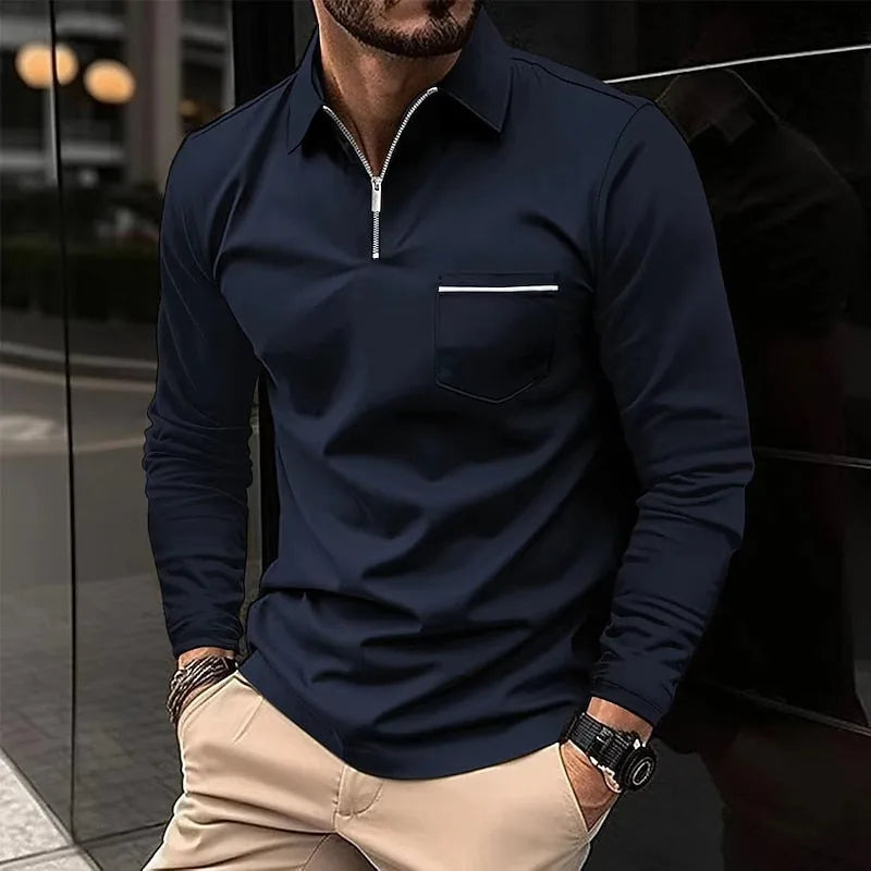 Man wearing a dark navy quarter-zip polo shirt with chest pocket and striped trim, styled with beige trousers