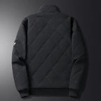 Rear view of black diamond-quilted jacket with ribbed cuffs, hem and small sleeve badge detail