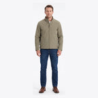 Man wearing the khaki jacket zipped up over a white t-shirt and jeans, styled with brown boots
