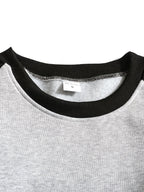 Front view of the raglan sweatshirt showing the crew neckline sitting close to the collarbone