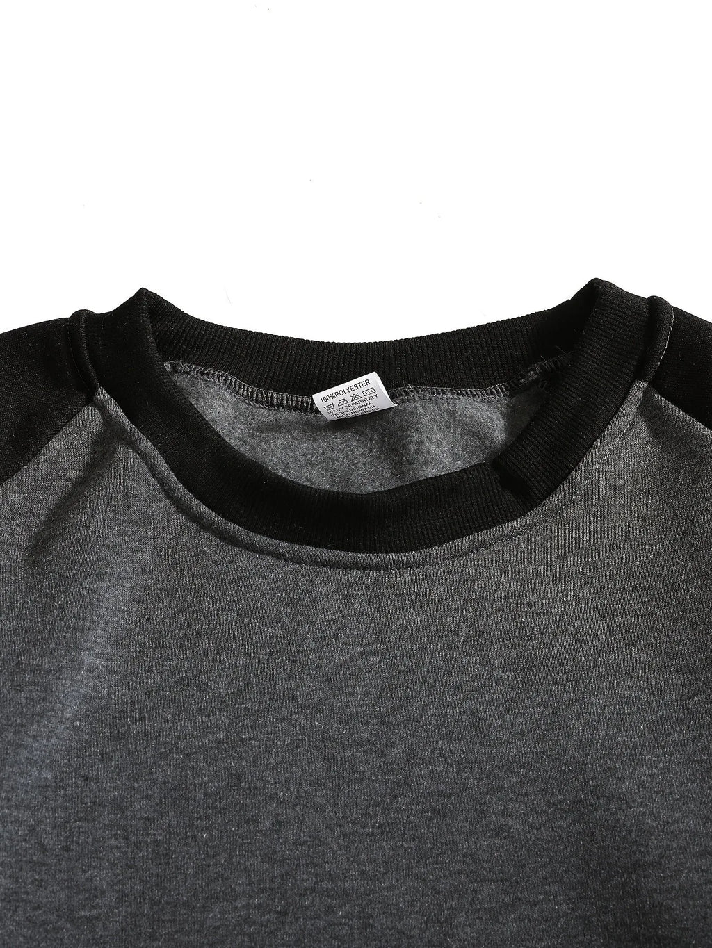 Close-up of the ribbed crew neckline and raglan seam detail in black and grey