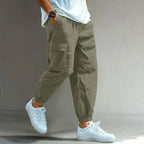 Olive green cargo trousers with elastic waistband and relaxed tapered leg, side profile shot with white trainers
