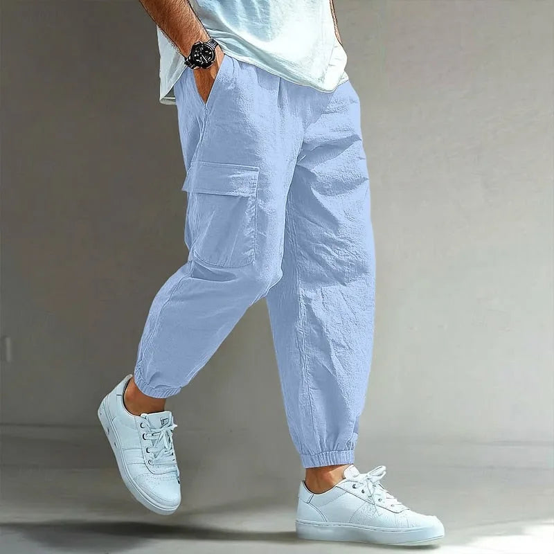 Pale blue cargo trousers with drawstring waist and roomy cargo pocket, relaxed tapered fit shown from the side