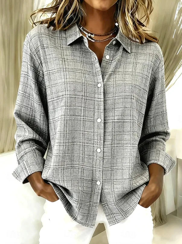 Grey checked button-up shirt shown with hands in pockets, highlighting the relaxed drop shoulder and cuffed sleeves