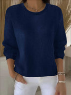 Navy blue knit jumper shown close-up with round ribbed neckline and relaxed long sleeves